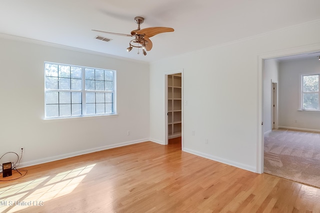 empty room featuring crown molding, ceiling fan, and light hardwood / wood-style floors