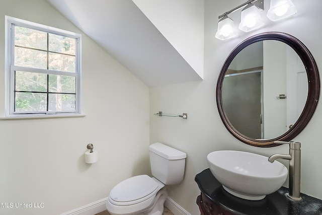 bathroom featuring lofted ceiling, sink, and toilet