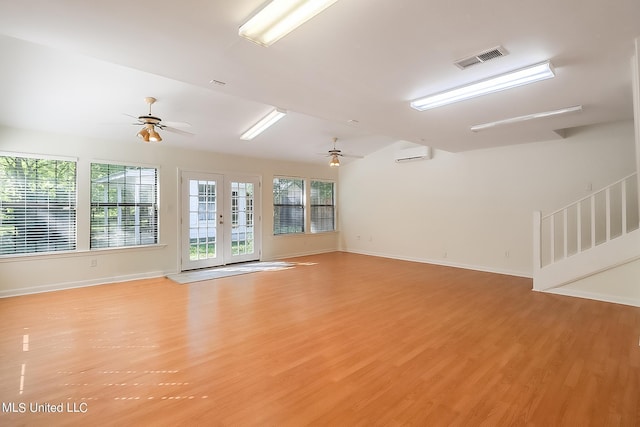 empty room with ceiling fan, light hardwood / wood-style floors, and a wall unit AC