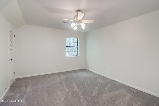 spare room featuring lofted ceiling, ceiling fan, and carpet flooring