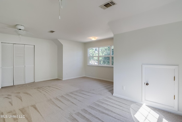 additional living space with light carpet and ceiling fan