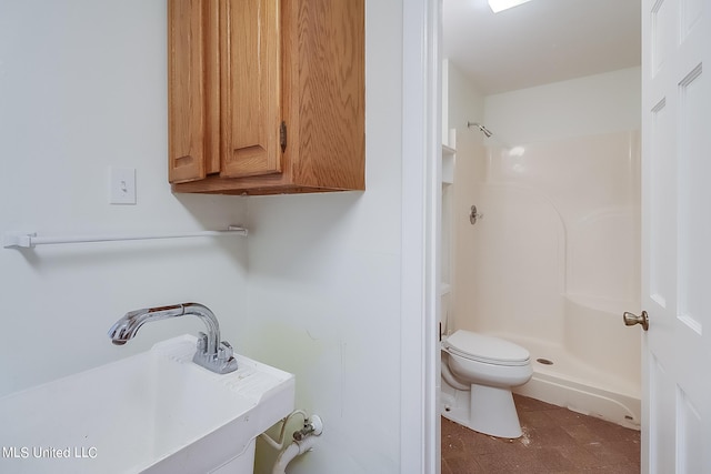 bathroom featuring walk in shower, toilet, and sink