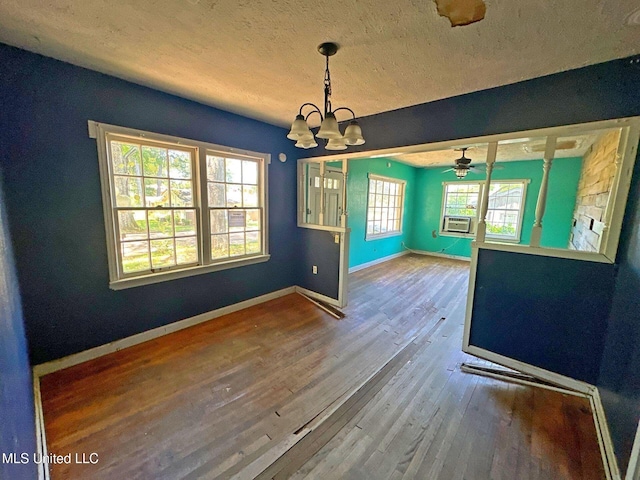 117 SE 5th Ave, Magee, MS 39111 - unfurnished dining area with a chandelier, wood finished floors, baseboards, a textured ceiling, and a ceiling fan