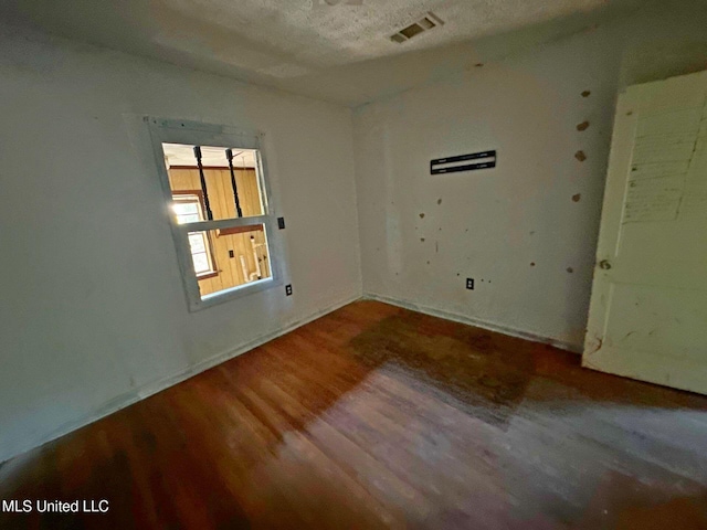 117 SE 5th Ave, Magee, MS 39111 - spare room with wood finished floors, baseboards, and a textured ceiling