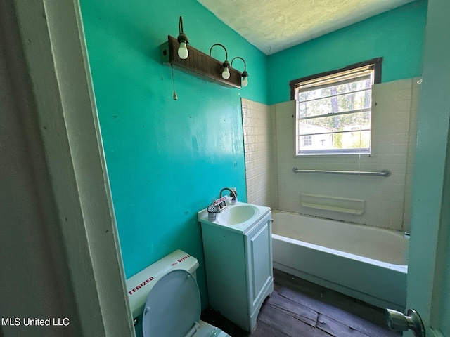 117 SE 5th Ave, Magee, MS 39111 - full bathroom with a textured ceiling, a bath, wood finished floors, toilet, and vanity