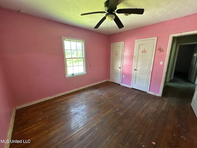 117 SE 5th Ave, Magee, MS 39111 - unfurnished bedroom featuring wood-type flooring, baseboards, a ceiling fan, and two closets