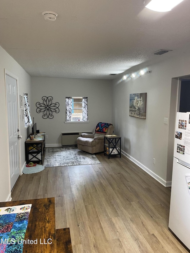 sitting room featuring baseboards, visible vents, and wood finished floors