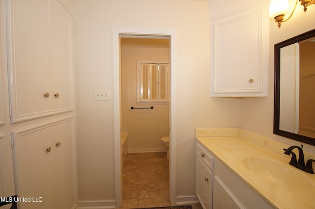 bathroom featuring toilet, a washtub, vanity, and tile patterned floors