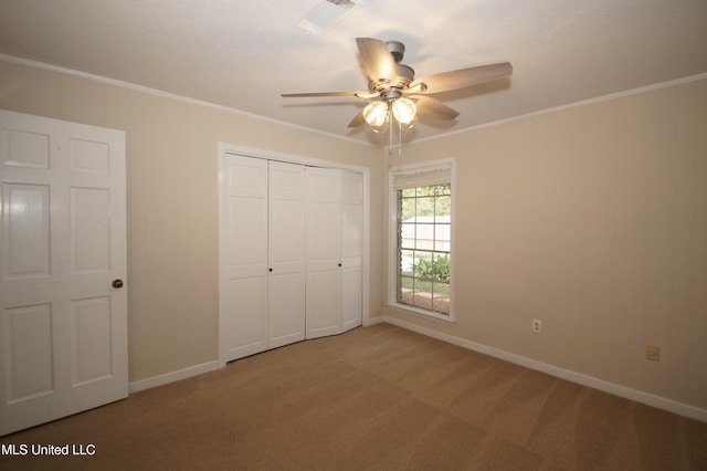 unfurnished bedroom with ornamental molding, carpet floors, and ceiling fan