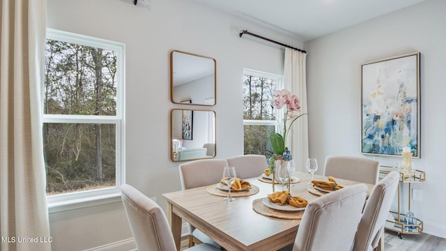 dining space featuring baseboards and wood finished floors