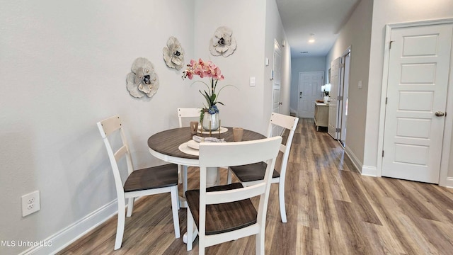 dining space with wood finished floors and baseboards