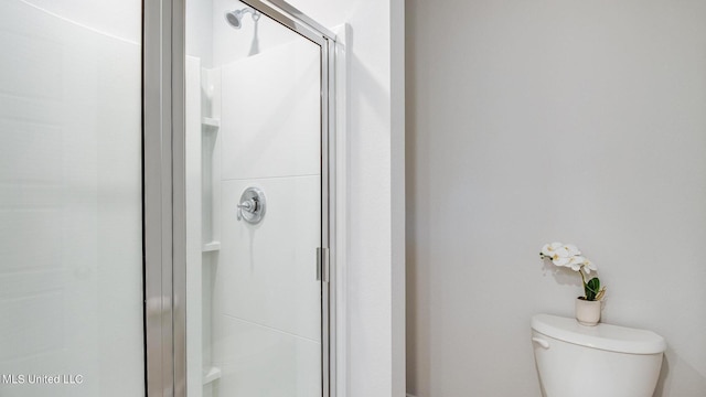 bathroom featuring a shower stall and toilet