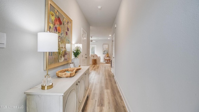 hallway with light wood-style floors and baseboards