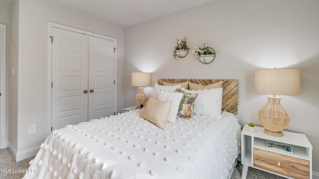 carpeted bedroom with a closet and baseboards