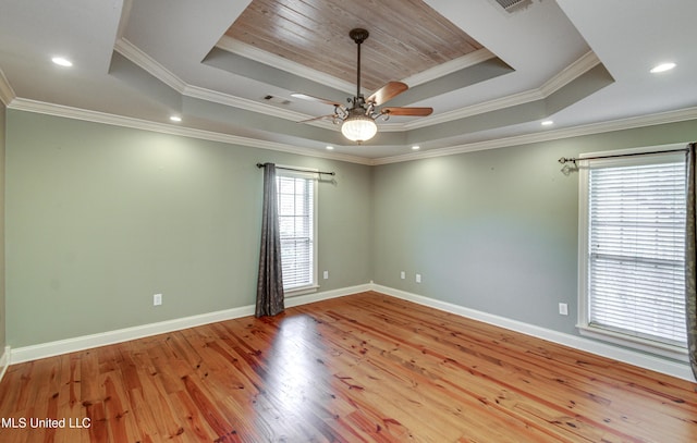 unfurnished room featuring light wood-type flooring, a raised ceiling, ceiling fan, and crown molding