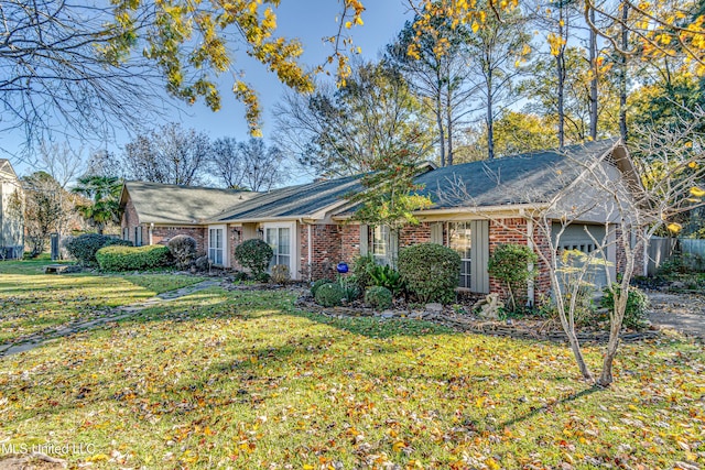 ranch-style house featuring a garage and a front lawn