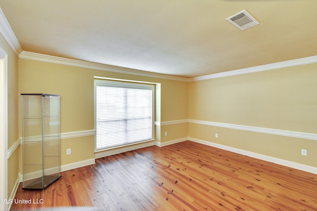 unfurnished room featuring hardwood / wood-style flooring and crown molding