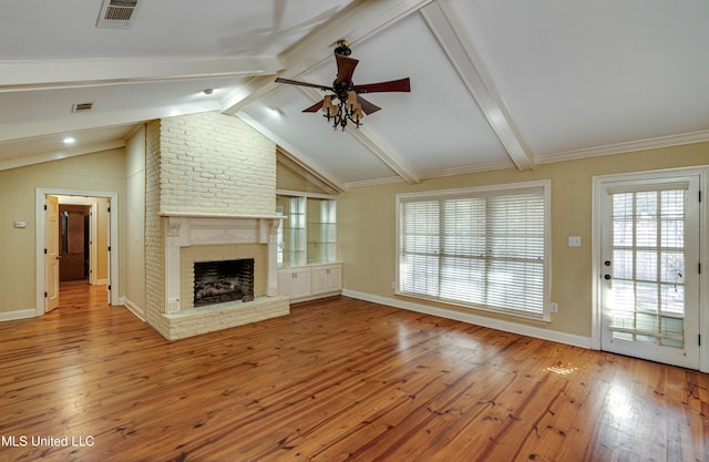 unfurnished living room with ceiling fan, vaulted ceiling with beams, wood-type flooring, a fireplace, and ornamental molding