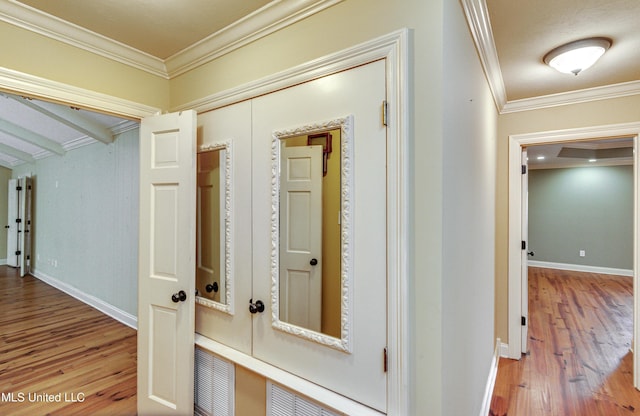 hallway featuring crown molding and light hardwood / wood-style flooring