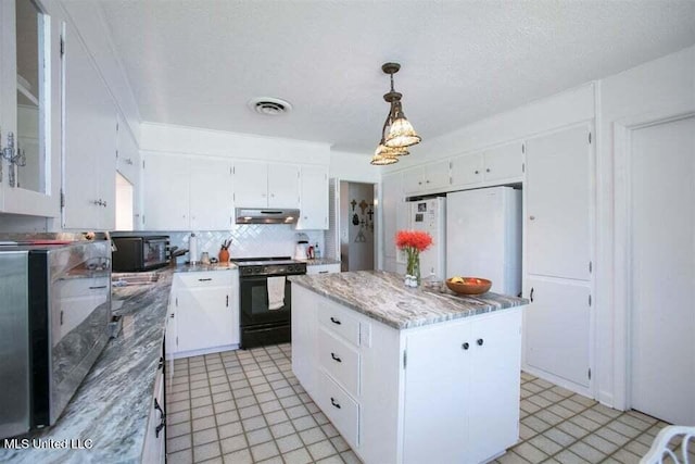 708 Ratliff Ferry Rd, Canton, MS 39046 - kitchen with black range with electric stovetop, white cabinets, a kitchen island, and decorative light fixtures