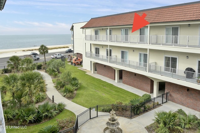 view of building exterior with a water view and a beach view