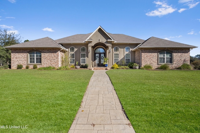 view of front of home with a front yard and french doors