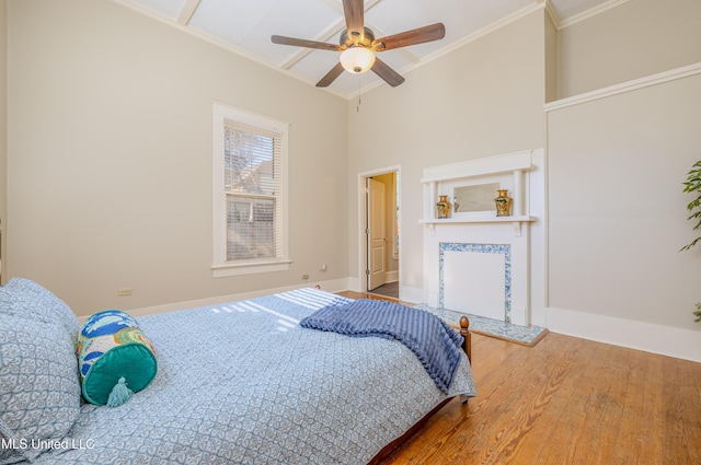 bedroom with ceiling fan, hardwood / wood-style floors, and ornamental molding