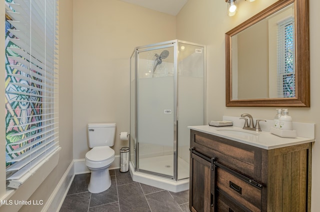 bathroom with tile patterned floors, a shower with door, vanity, and toilet