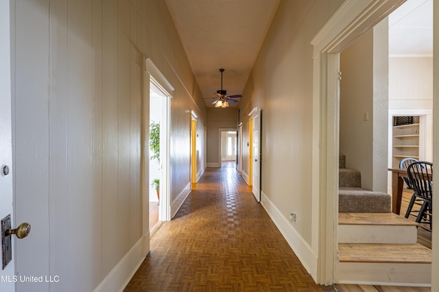 corridor featuring wooden walls and dark parquet floors