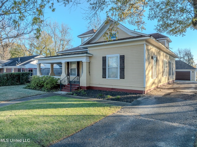 neoclassical / greek revival house featuring covered porch, a garage, a front lawn, and an outdoor structure