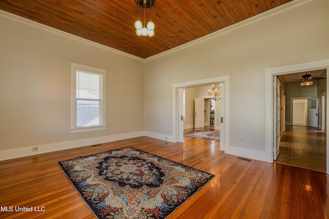 empty room featuring crown molding, wood ceiling, ceiling fan with notable chandelier, and hardwood / wood-style flooring