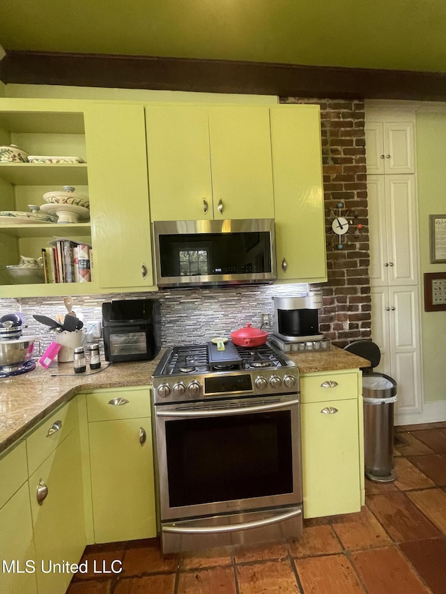 800 Gillespie St, Jackson, MS 39202 - kitchen featuring appliances with stainless steel finishes, decorative backsplash, light countertops, and yellow cabinets