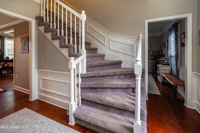 stairway with hardwood / wood-style flooring and ornamental molding