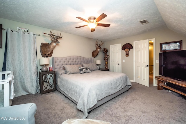 carpeted bedroom featuring ceiling fan and a textured ceiling