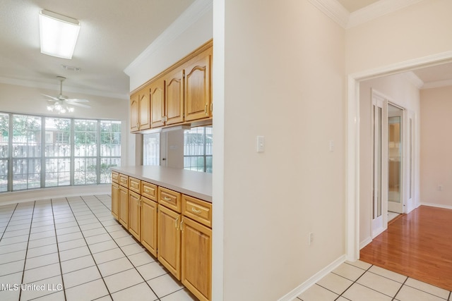 696 Aukai Pl, Diamondhead, MS 39525 - kitchen with light tile patterned flooring, a ceiling fan, crown molding, light countertops, and baseboards