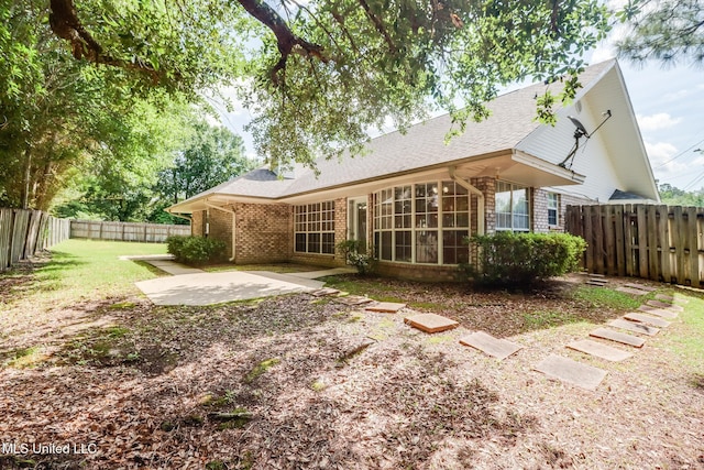 696 Aukai Pl, Diamondhead, MS 39525 - back of house with brick siding, a patio area, a fenced backyard, and roof with shingles