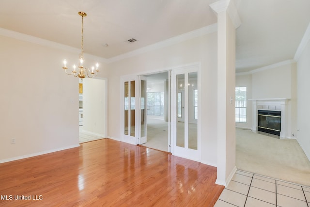 696 Aukai Pl, Diamondhead, MS 39525 - unfurnished dining area with crown molding, a chandelier, a high end fireplace, light wood-style flooring, and baseboards