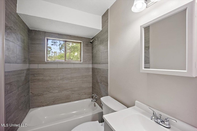 full bathroom with tiled shower / bath, vanity, a textured ceiling, and toilet