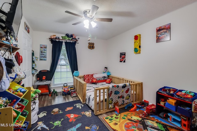 730 Holly Hills Dr, Biloxi, MS 39532 - bedroom featuring wood finished floors, a ceiling fan, and a nursery area