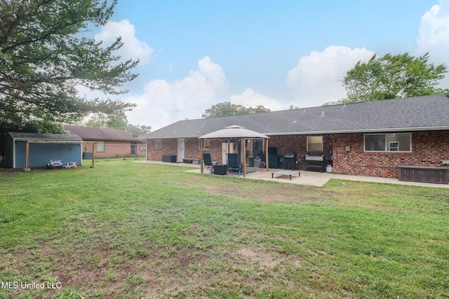 730 Holly Hills Dr, Biloxi, MS 39532 - back of house featuring a patio area, a lawn, brick siding, and a storage shed