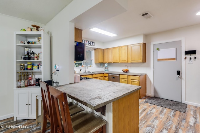 730 Holly Hills Dr, Biloxi, MS 39532 - kitchen featuring stainless steel dishwasher, light wood-style floors, a breakfast bar, a peninsula, and light countertops