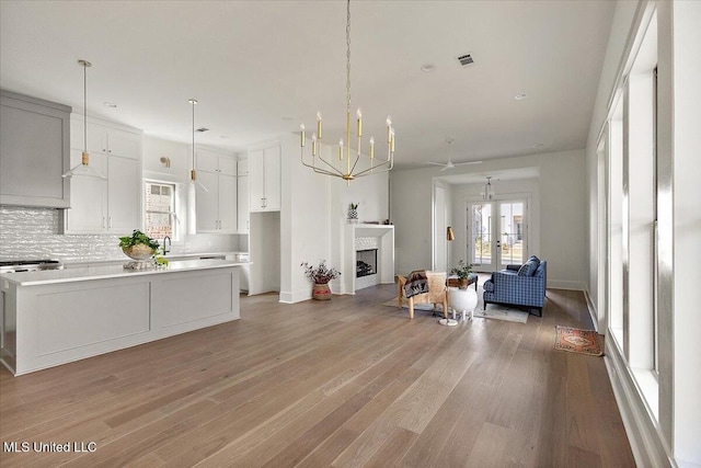 113 Water St, Madison, MS 39110 - kitchen with open floor plan, a chandelier, white cabinets, light wood finished floors, and light countertops