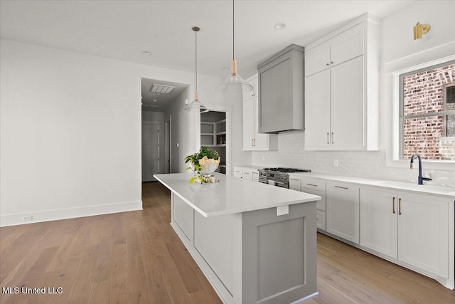 113 Water St, Madison, MS 39110 - kitchen featuring a sink, backsplash, a kitchen island, light wood-style floors, and light countertops