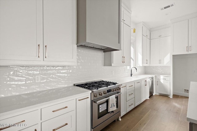 113 Water St, Madison, MS 39110 - kitchen with stainless steel appliances, a sink, white cabinets, and light wood finished floors