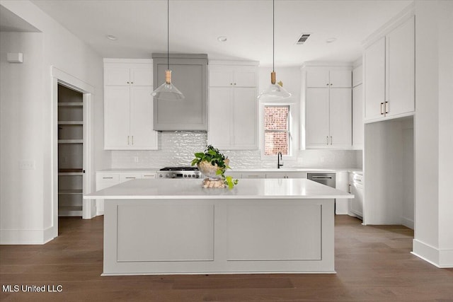 113 Water St, Madison, MS 39110 - kitchen with a kitchen island, white cabinets, a sink, decorative backsplash, and dark wood finished floors