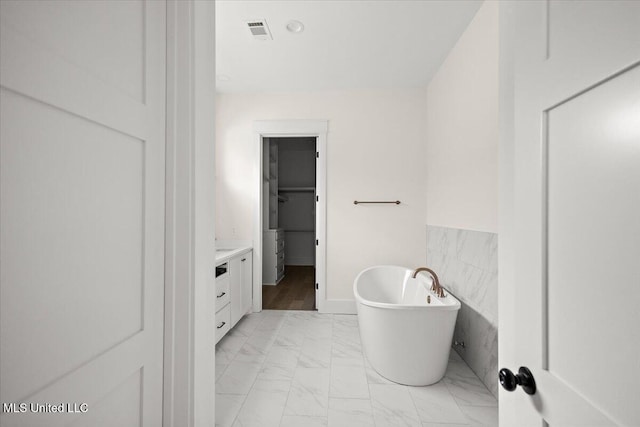113 Water St, Madison, MS 39110 - full bath featuring marble look tile flooring, a freestanding bath, vanity, and a spacious closet