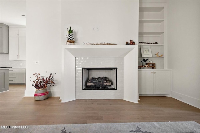 113 Water St, Madison, MS 39110 - living area with wood finished floors, a fireplace, and built in shelves