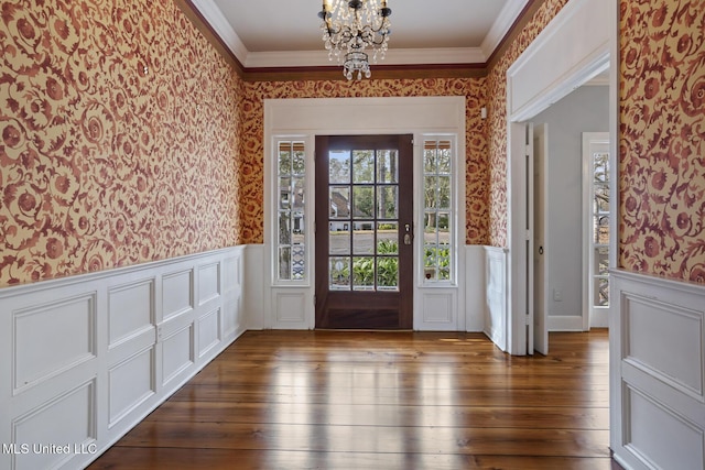 foyer entrance featuring crown molding, dark hardwood / wood-style flooring, and a notable chandelier