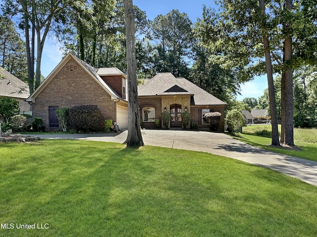 214 Terrapin Creek Rd, Brandon, MS 39042 - french country inspired facade featuring french doors, brick siding, a front lawn, concrete driveway, and a garage