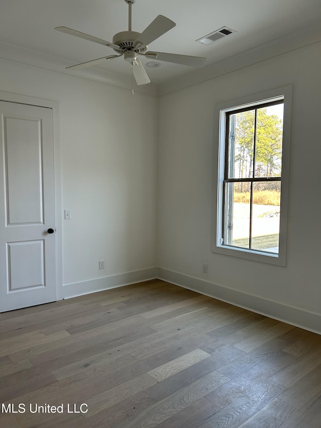 spare room with ceiling fan, light wood-type flooring, and ornamental molding